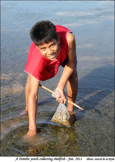 A Tumibo youth collecting shellfish