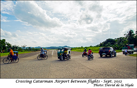 Vehicles crossing Catarman Airport between flights.