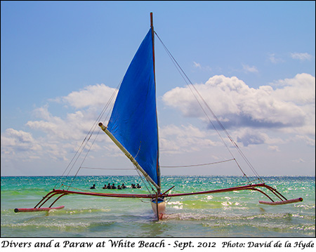 Scuba divers and a Paraw at White Beach