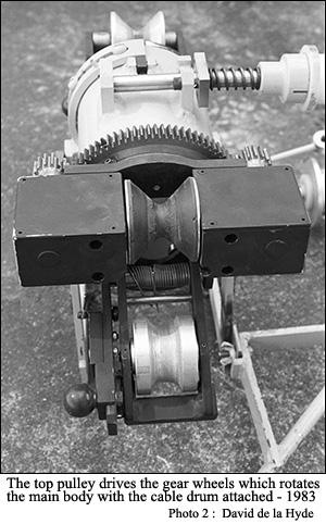 The top pulley drives the gear wheels which rotates the main body with the cable drum attached